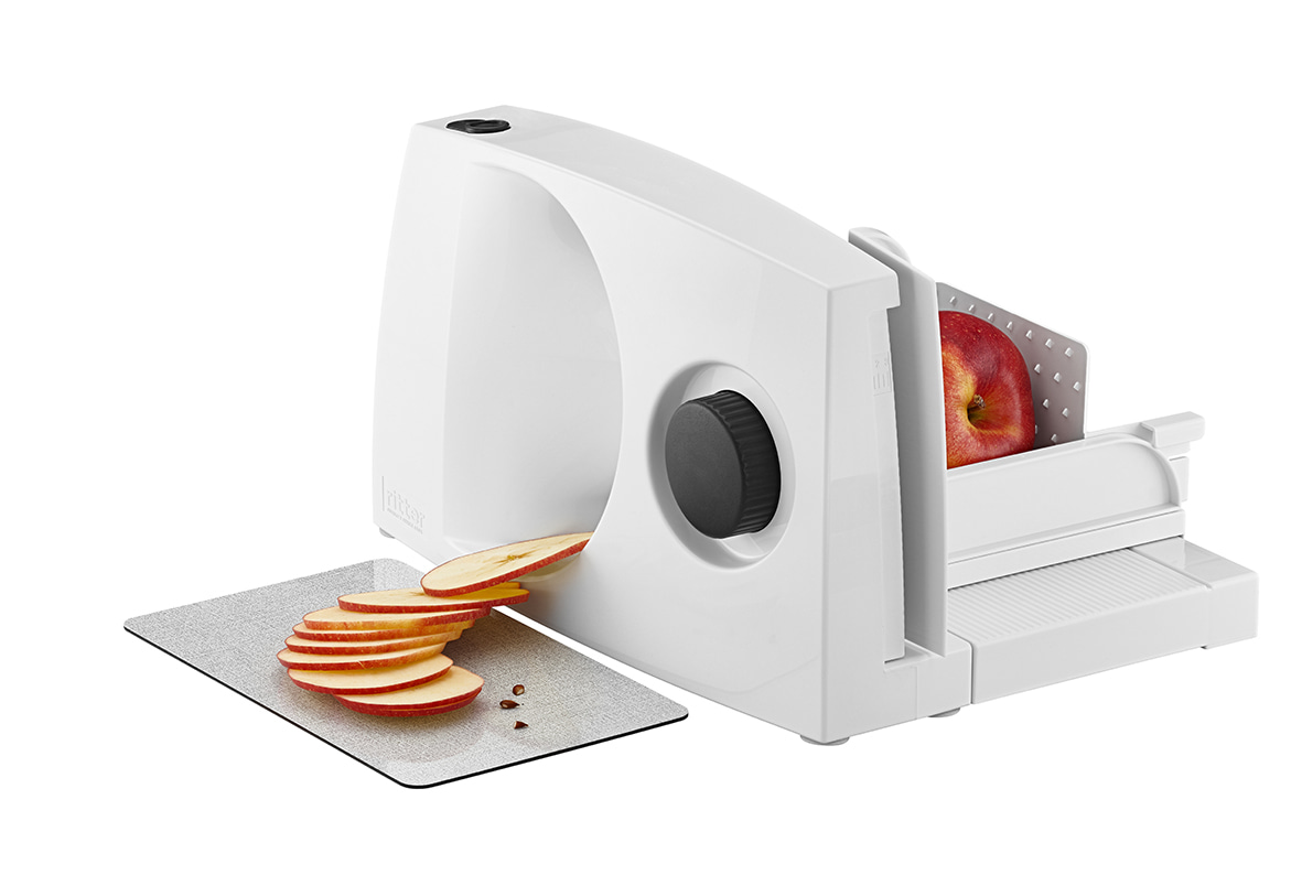 White food slicer made of plastic, side view with sliced apple