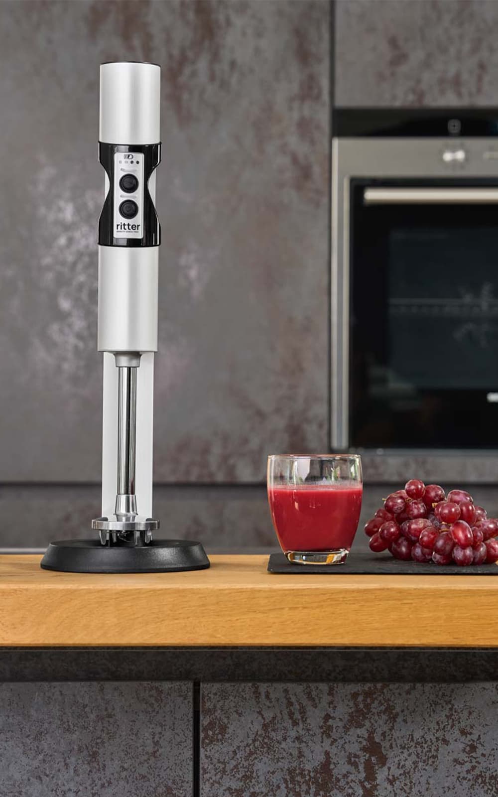 Hand blender in modern kitchen with juice and grapes Hand blender in modern kitchen with juice and grapes