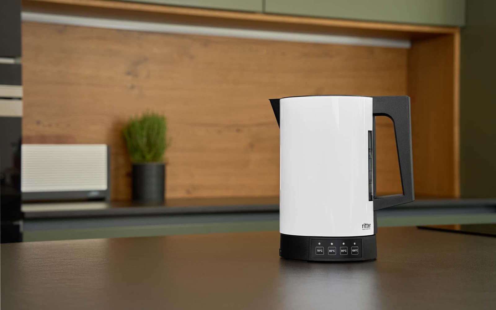A picture of the white kettle standing on a kitchen platform.