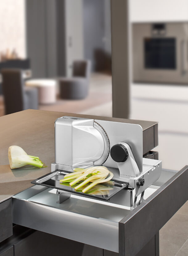 Built-in food slicer in modern kitchen with sliced food