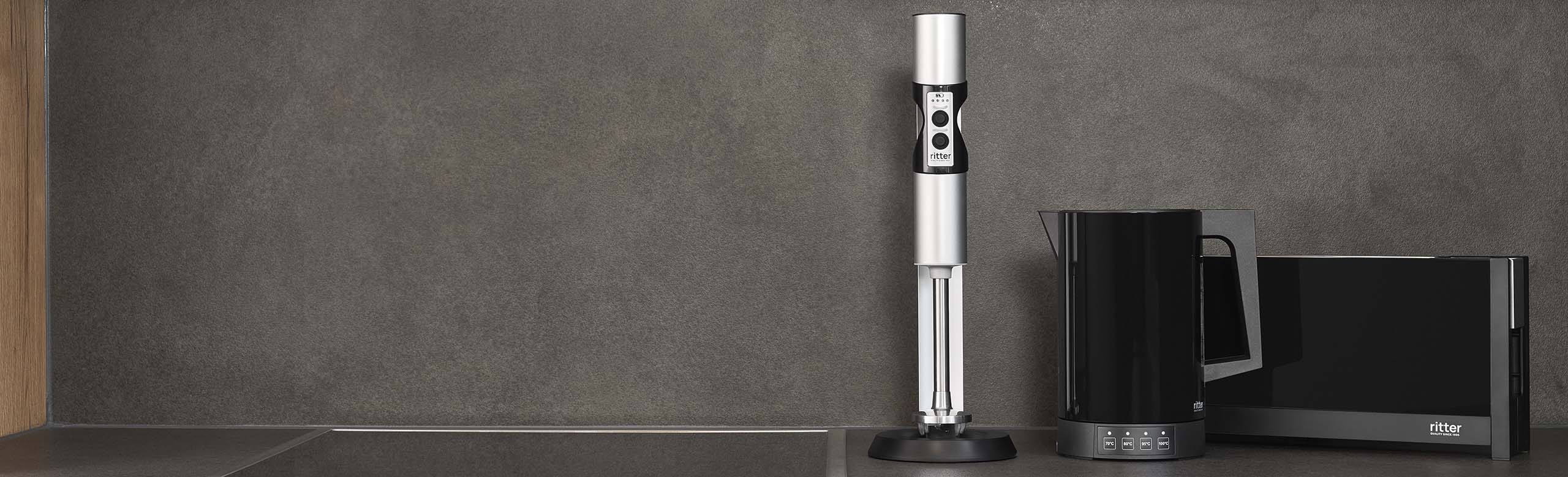A picture of a hand blender, kettle and toaster in a dark kitchen