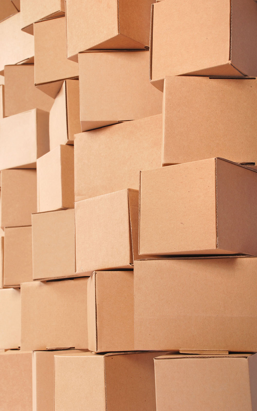 Stacked cardboard boxes made of brown corrugated cardboard.