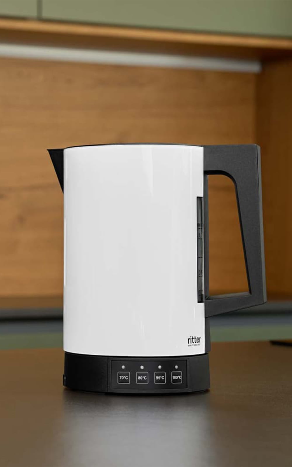 A picture of the white kettle standing on a kitchen platform. A picture of the white kettle standing on a kitchen platform.