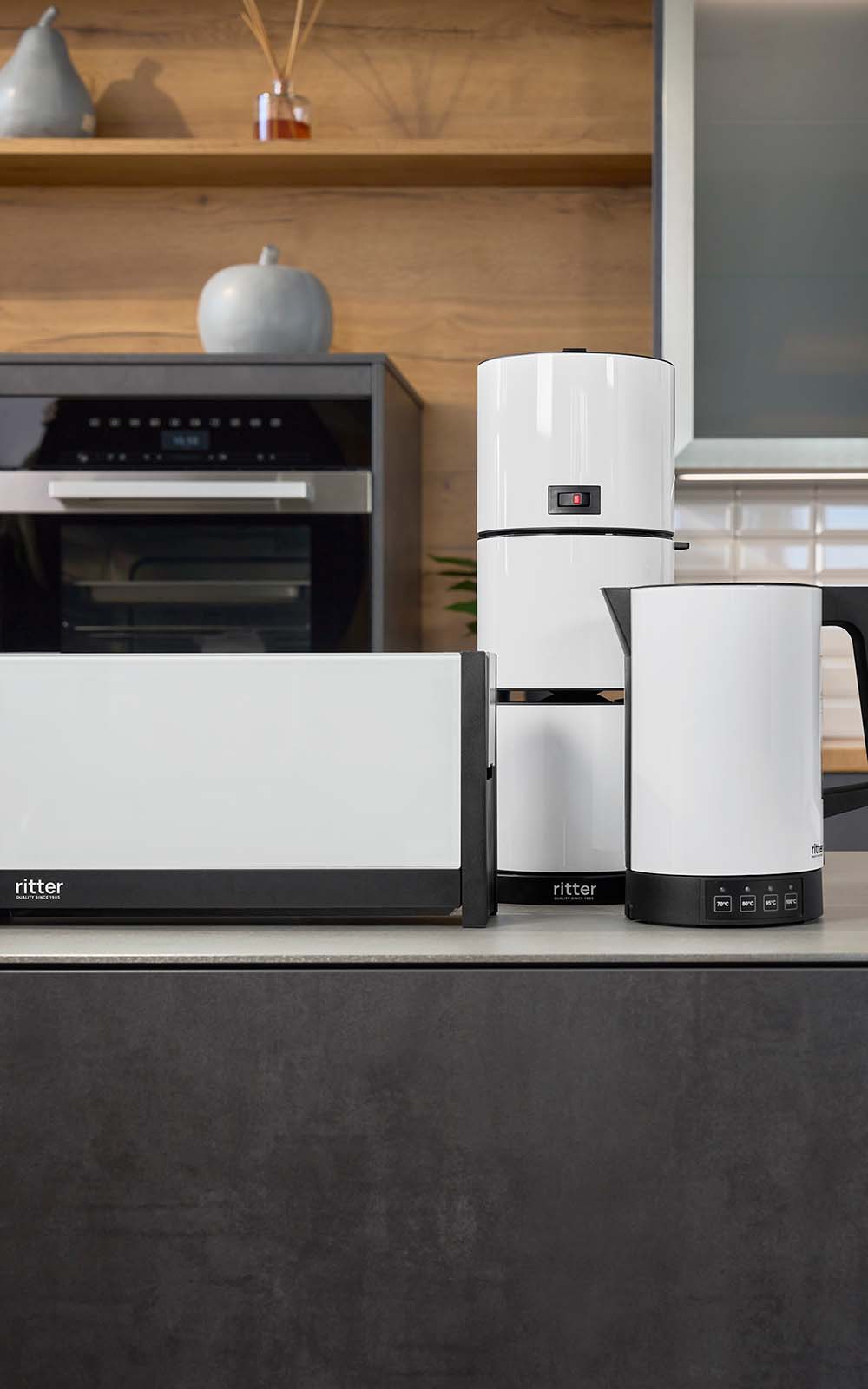 Breakfast set with white toaster, white coffee machine and white kettle in black kitchen Breakfast set with white toaster, white coffee machine and white kettle in black kitchen