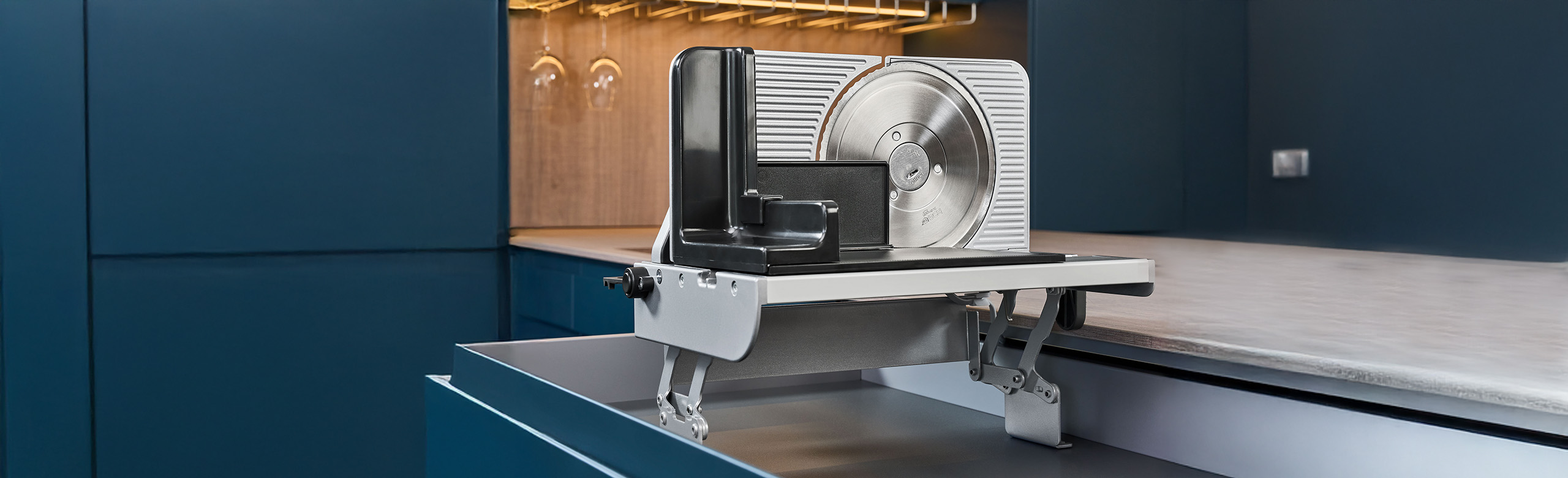 Ein Bild von einem Einbau-Allesschneider der aus einer Küchenschublade hervorkommt.