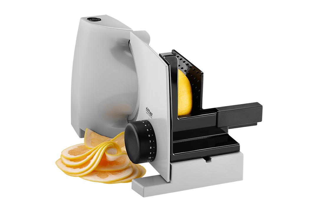 Electric food slicer in silver, angled view with sliced food