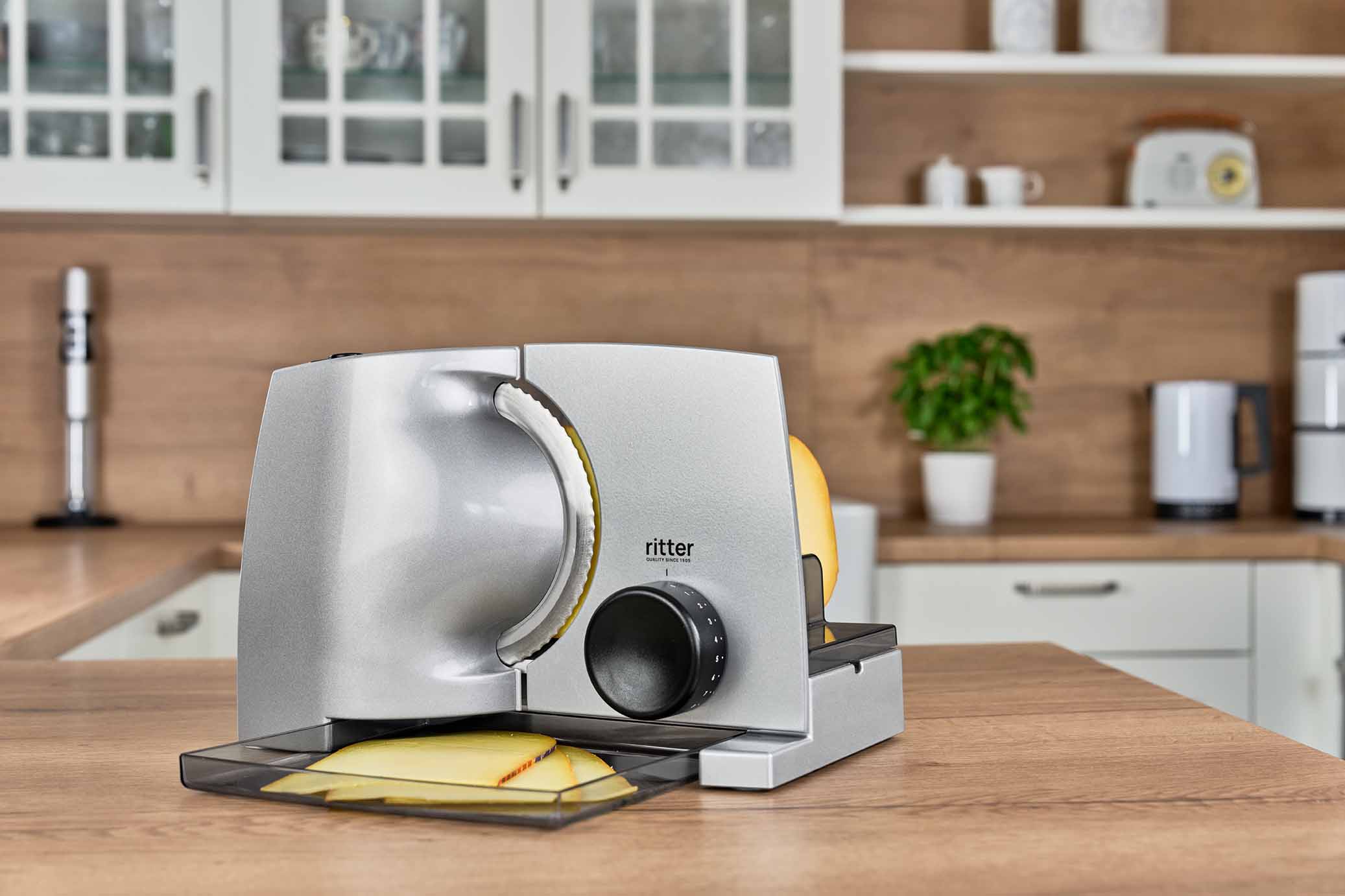 Electric food slicer with sliced cheese, in modern kitchen