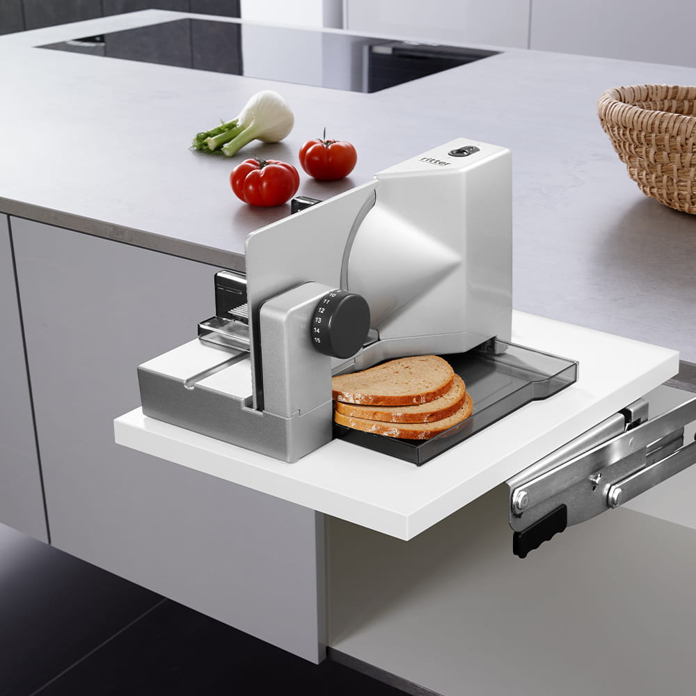Swing-out built-in food slicer in kitchen with sliced bread Swing-out built-in food slicer in kitchen with sliced bread