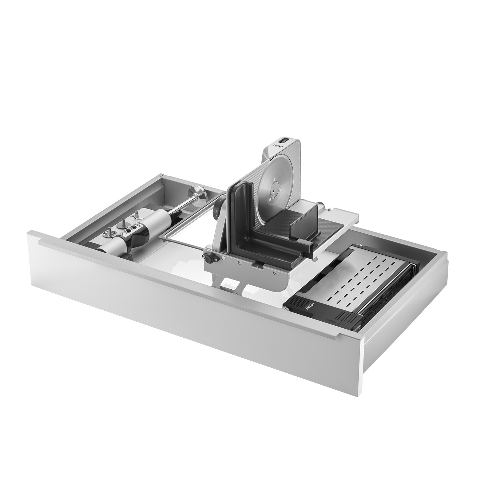 Ein Bild einer Schublade, mit einer Einbau-Kombination aus einem Einbau-Stabmixer, einem Einbau-Toaster und einem rechtsgeführten und aufgestellten Einbau-Allesschneider, mit weißem Hintergrund.